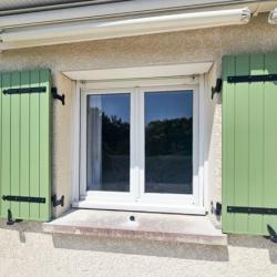 Installation de volets battants verts en aluminium